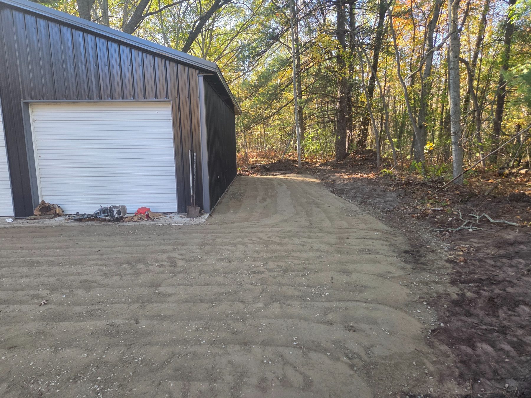 Additional crushed concrete parking space alongside garage